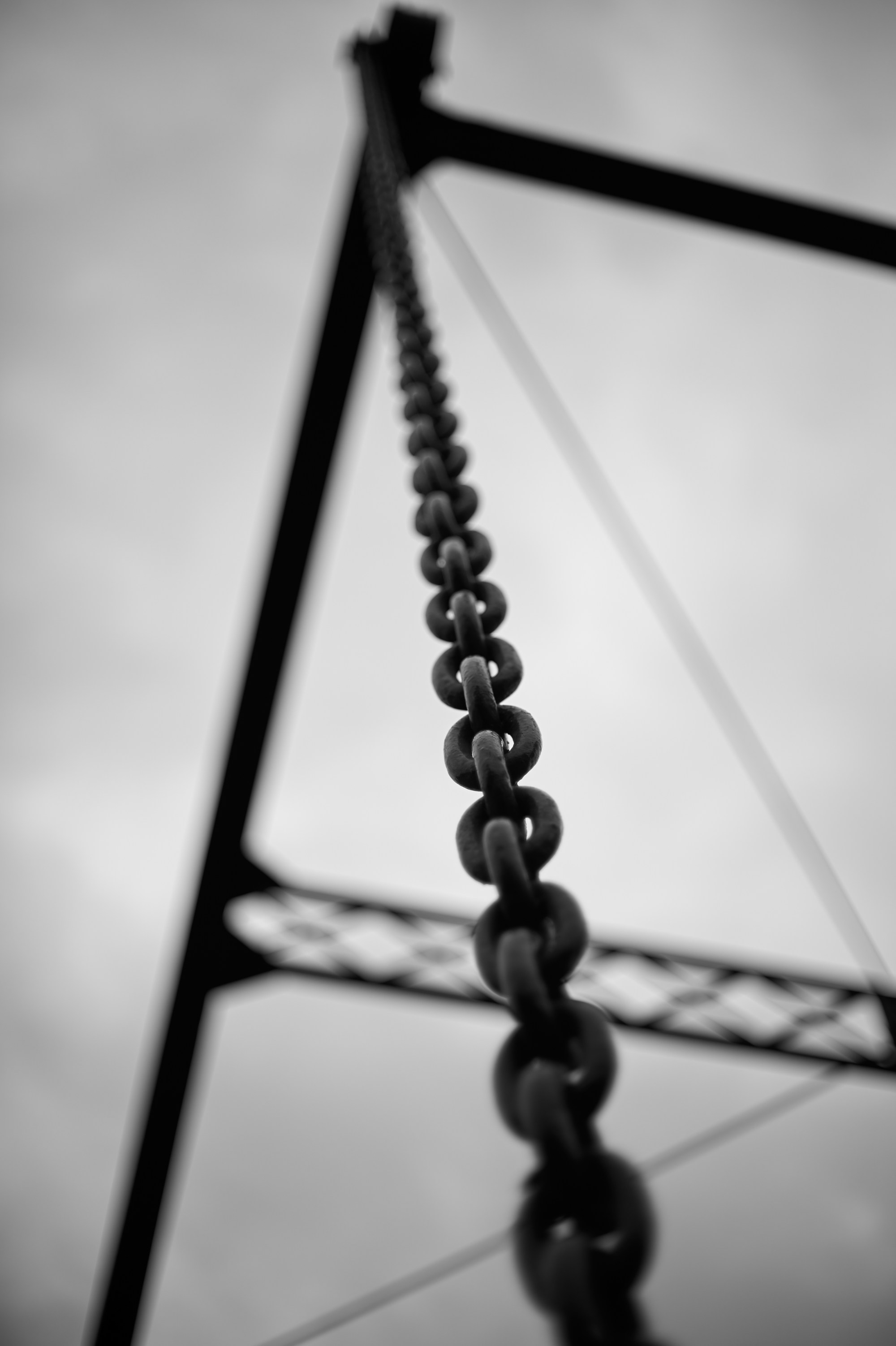 Cadena y estructura metálica en contrapicado contra el cielo.