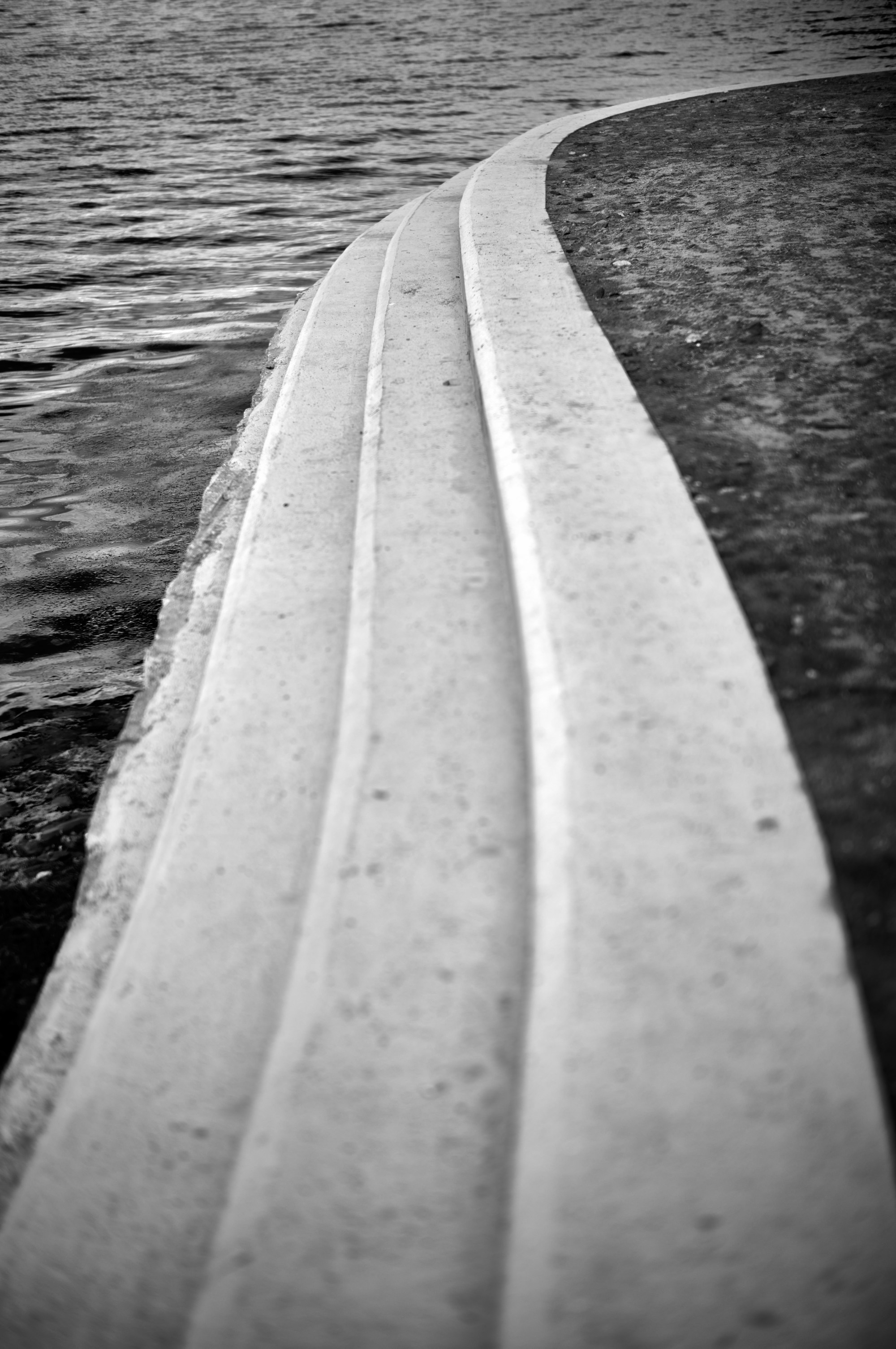 Borde curvo de hormigón junto al agua.