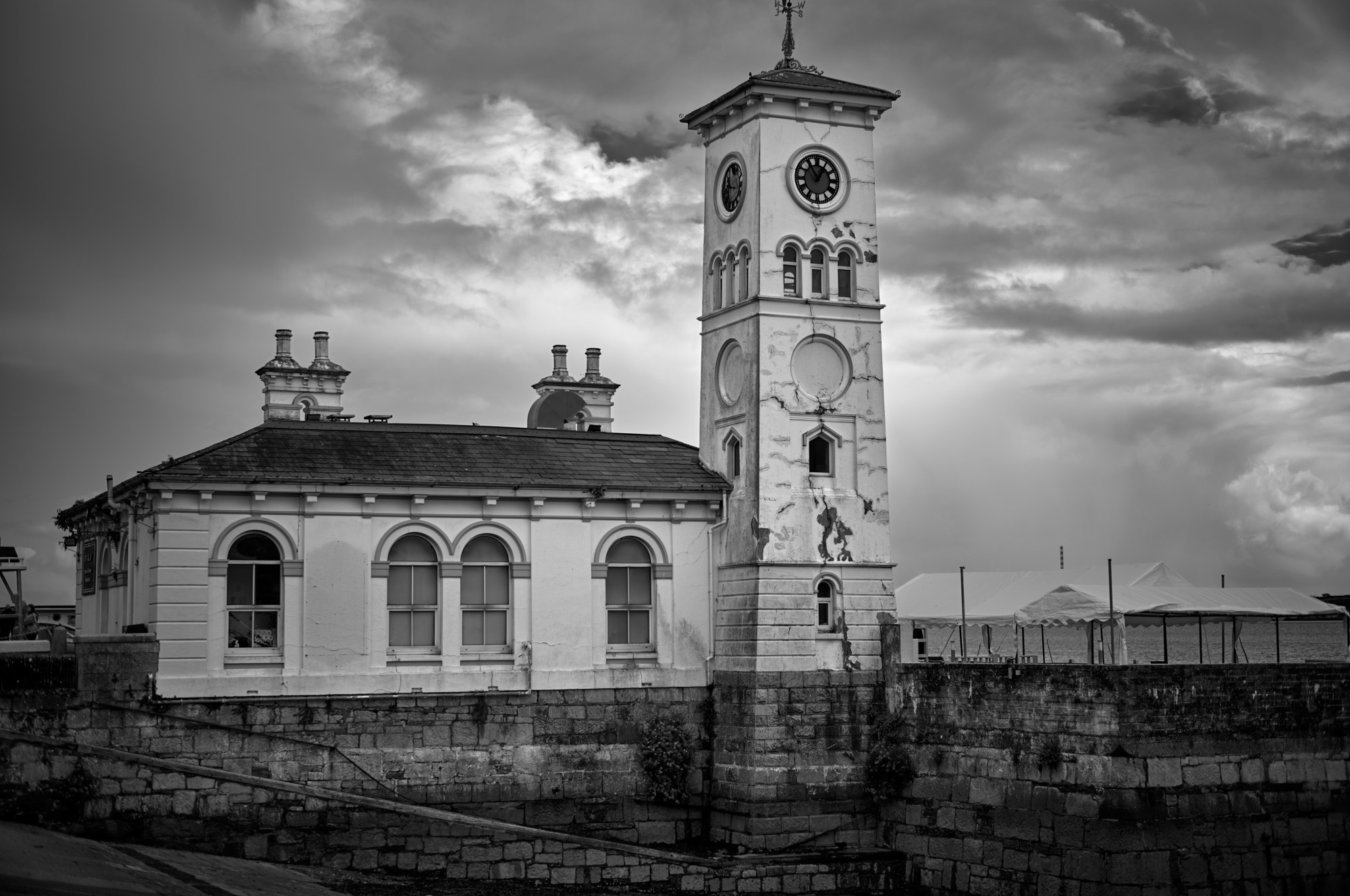 Edificio de piedra con torre de reloj bajo un cielo nublado.