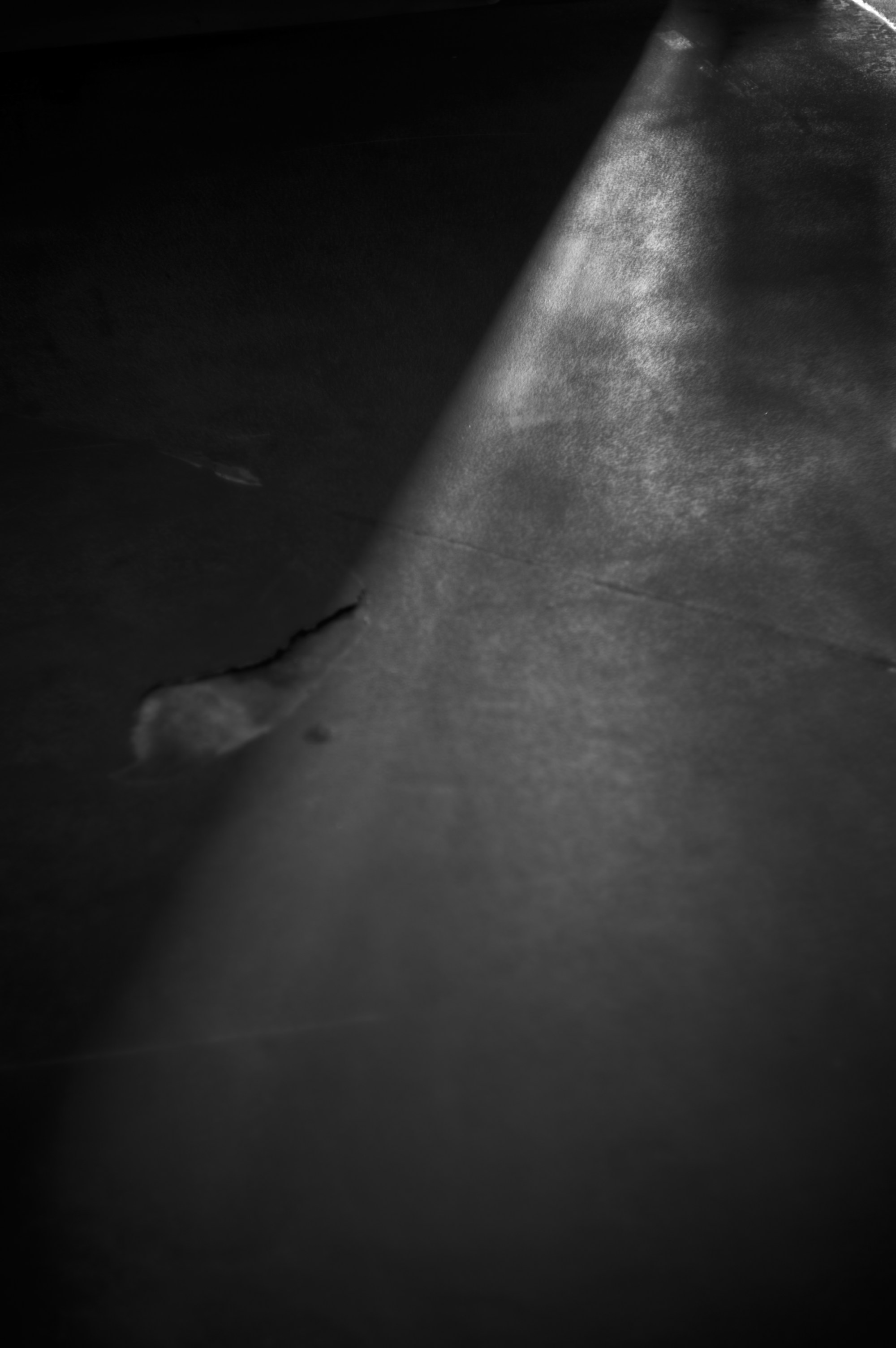 Superficie oscura atravesada por una franja de luz en diagonal.